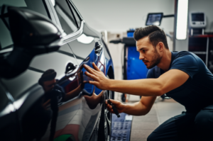 Professional auto body car repair technician inspecting collision damage at Hyperion Auto Repair in Los Angeles