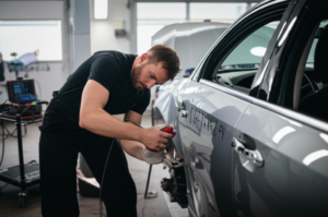 Professional mechanic inspecting auto body damage at Hyperion Auto Repair in Los Angeles