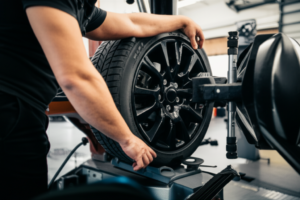 Professional mechanic performing tire rotation and wheel balancing service at Hyperion Auto Repair in Los Angeles