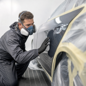 Technician inspecting a refinished car door panel during collision repair in Los Angeles